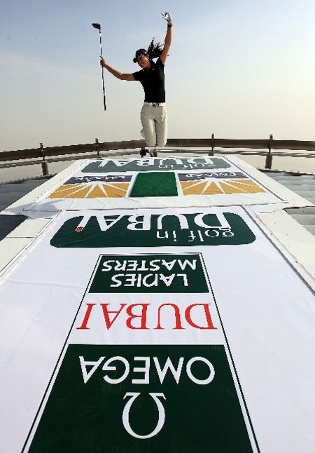 Michelle Wie jumps with joy after taking a swing at the 124th storey of Burj Dubai