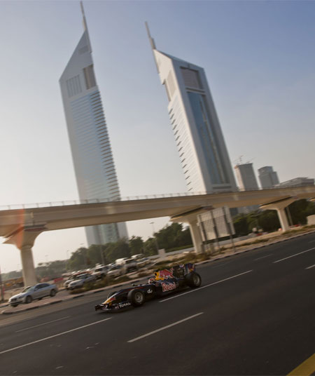 The Red Bull Racing F1 show car driving along Sheikh Zayed Road